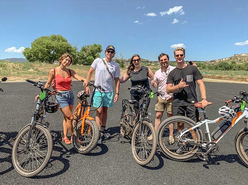 Group of Young Ebike Riders Posing for Photo in Parking Lot