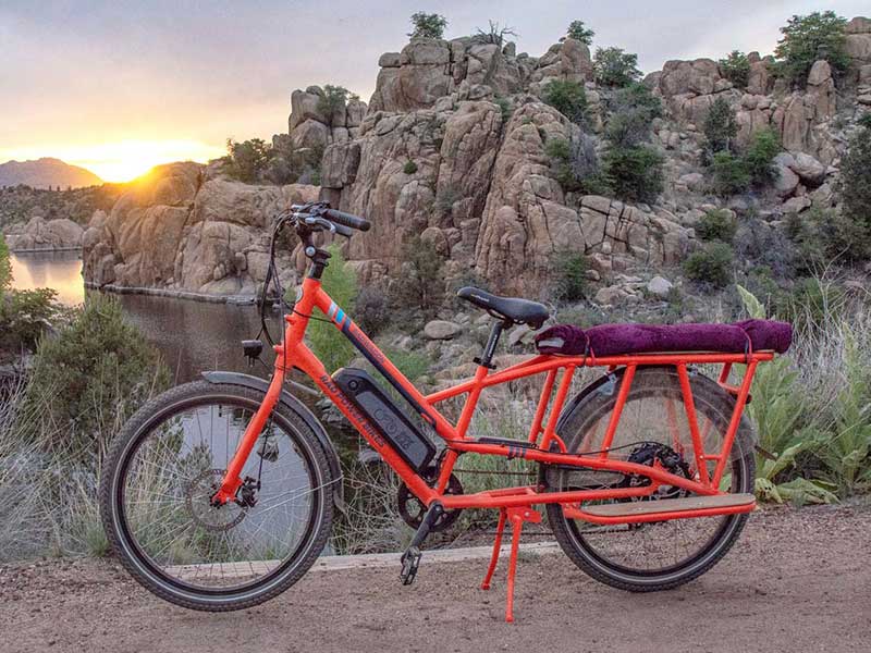 Orange Ebike with Cargo Space Parked in Front of Scenic Lake